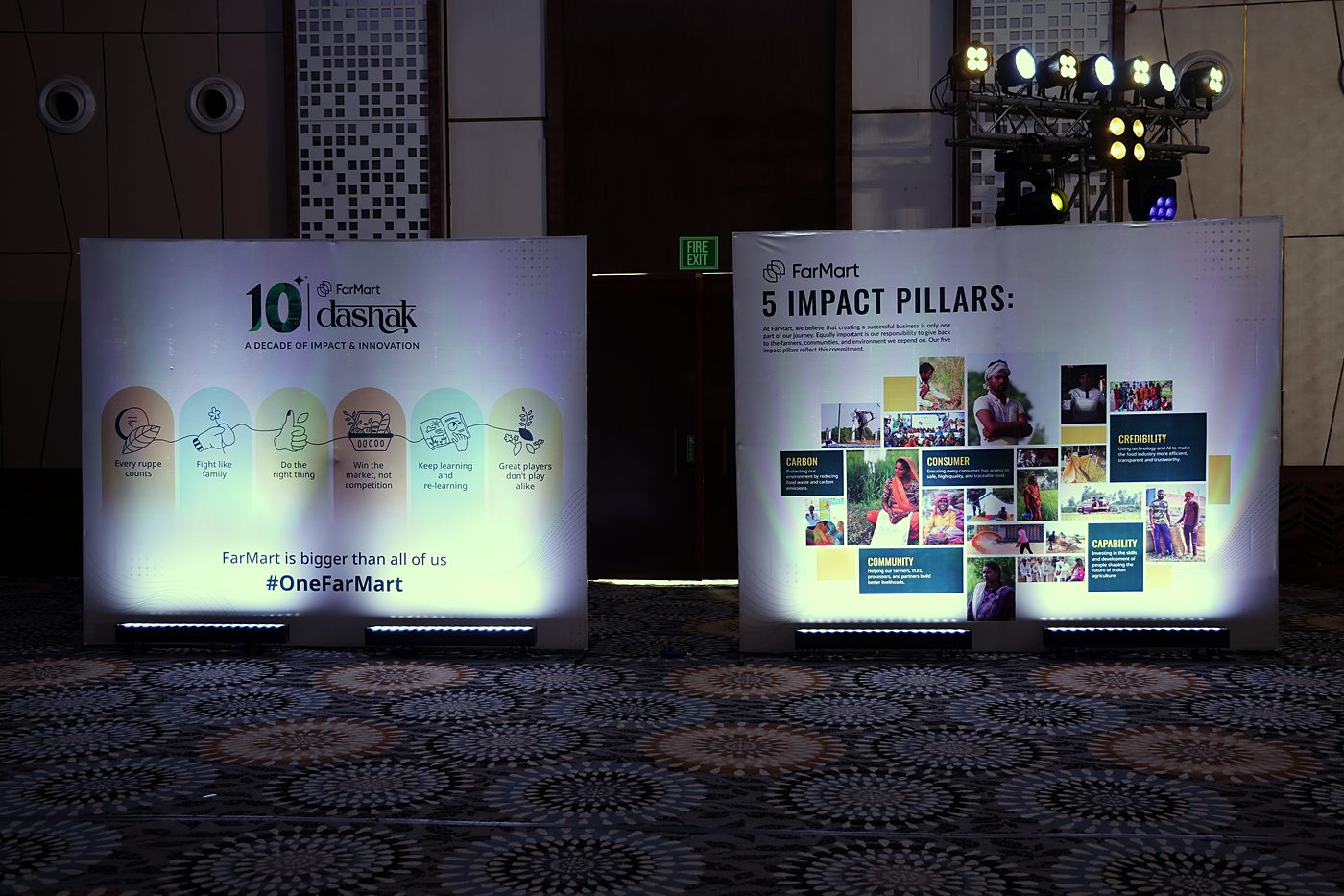 Two lit boards: FarMart's values with illustrated arches under the dashak lockup, and a board titled 5 Impact Pillars with a photo collage.
